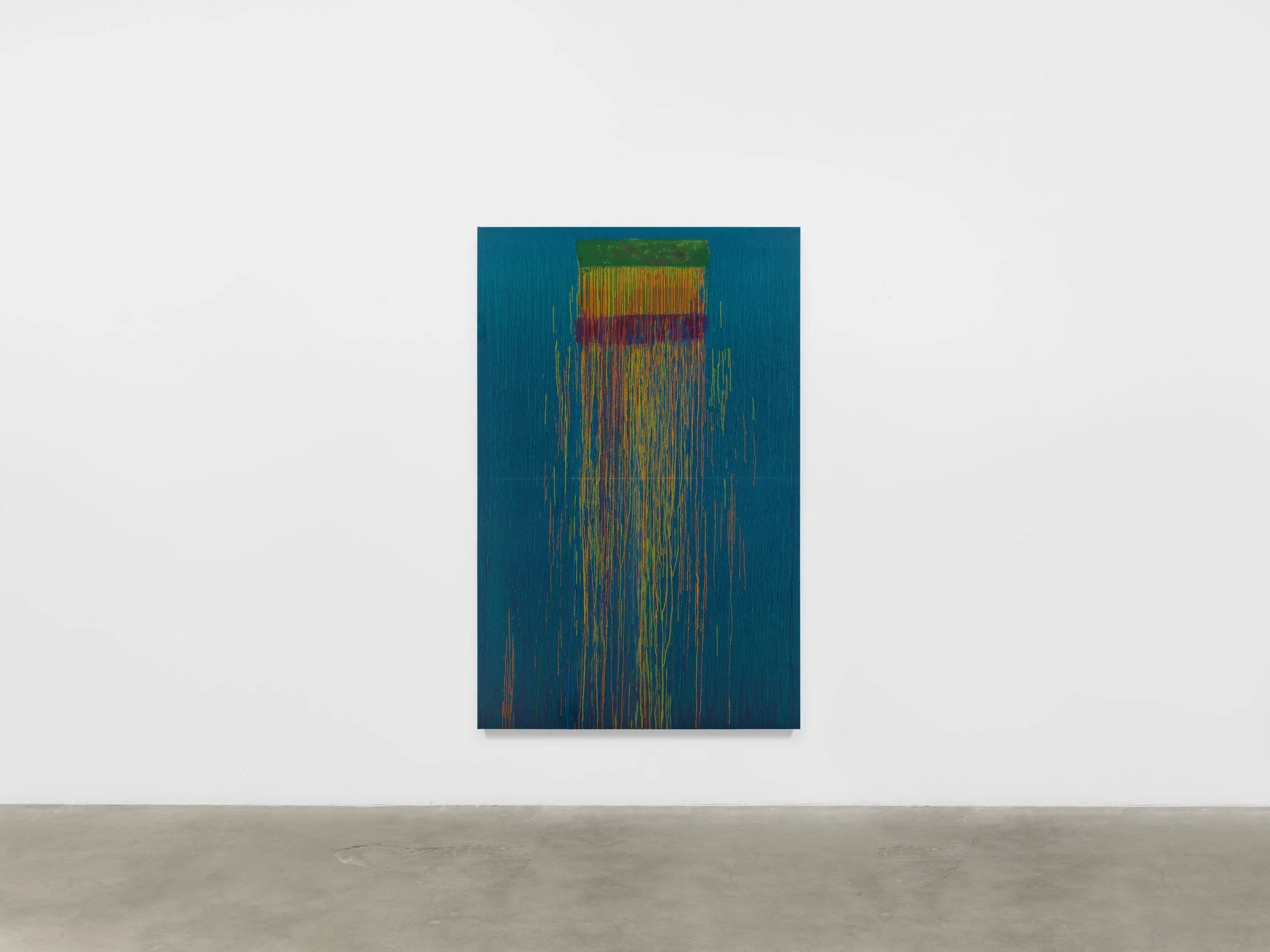 Abstract painting with vertical streaks of yellow, orange, red, and green on a blue background, displayed on a white gallery wall.