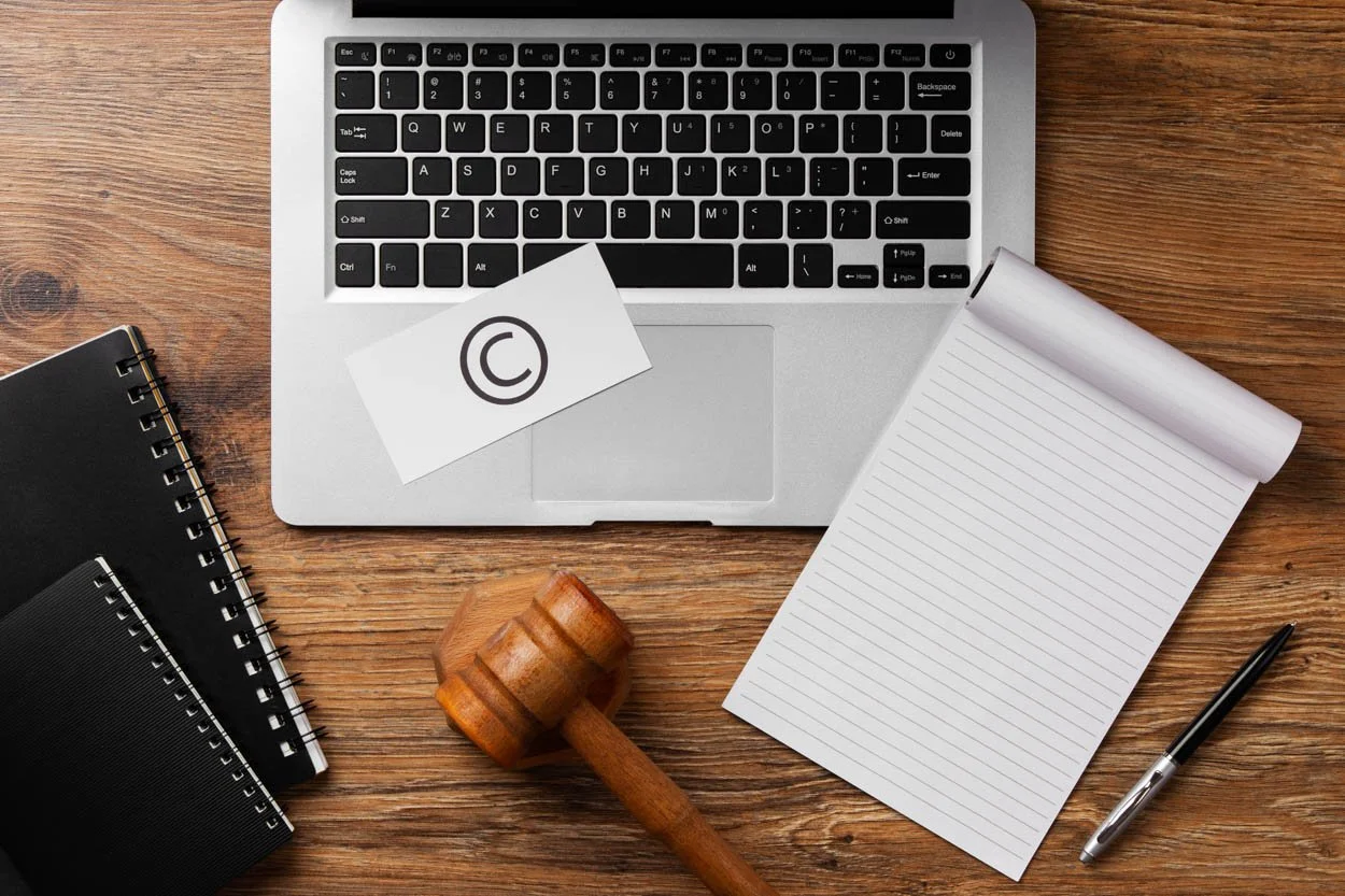 laptop on desk with a copyright symbol on a postcard