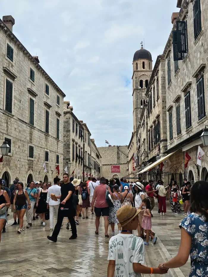 Crowded historic street during cultural event with festivals, local atmosphere and traditional architecture