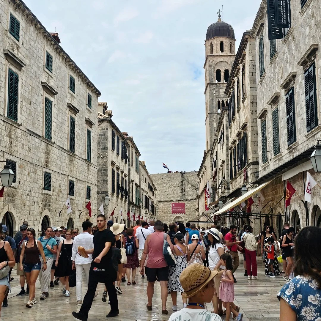 Crowded historic street during cultural event with festivals, local atmosphere and traditional architecture