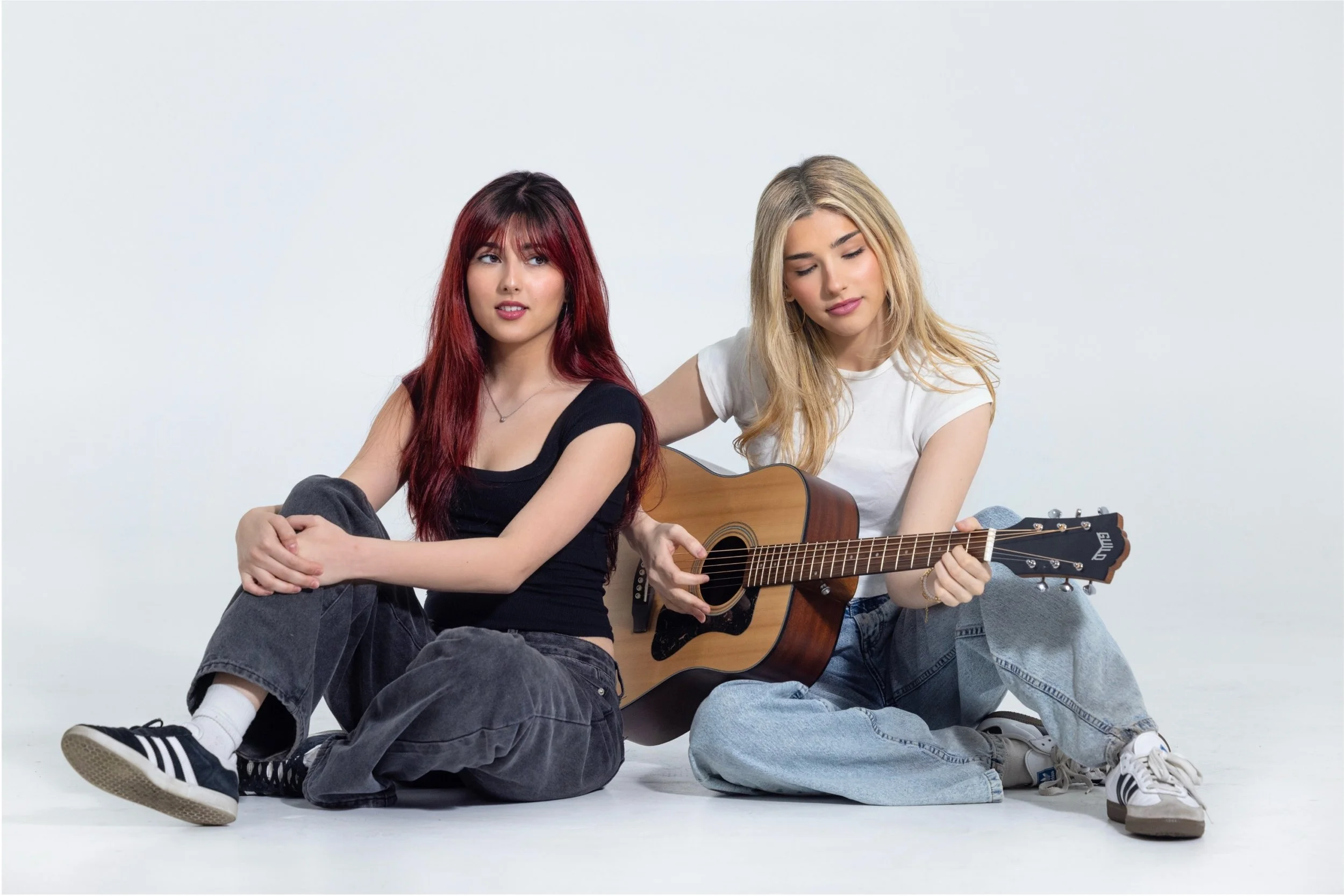 Esther and Rebecca sitting and playing guitar