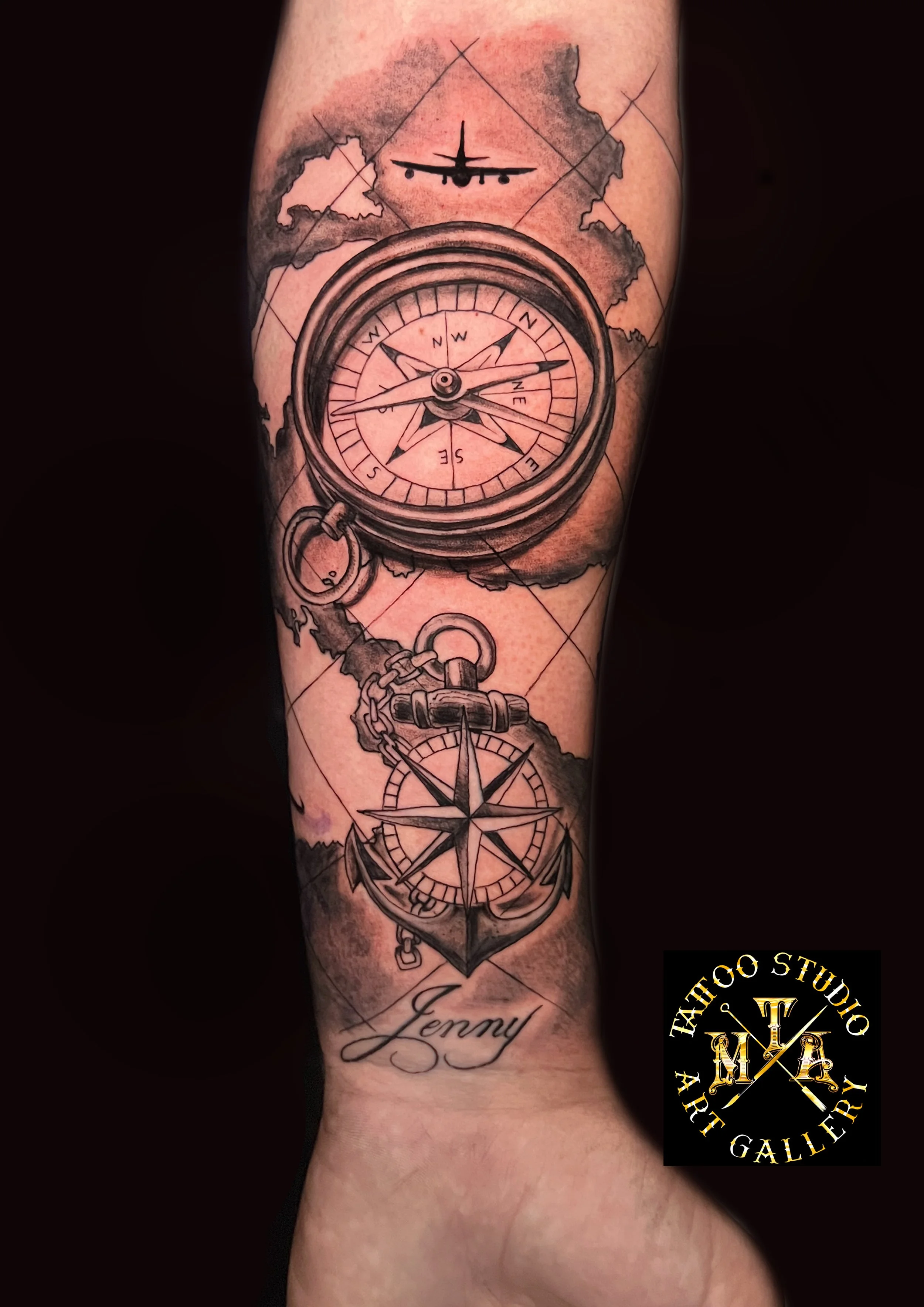 Tatuaggio di una bussola, un orologio da tasca con un'ancora e una rosa dei venti, sopra un nome scritto in corsivo 'Jenny', con un logo di uno studio di tatuaggi in basso a destra.
