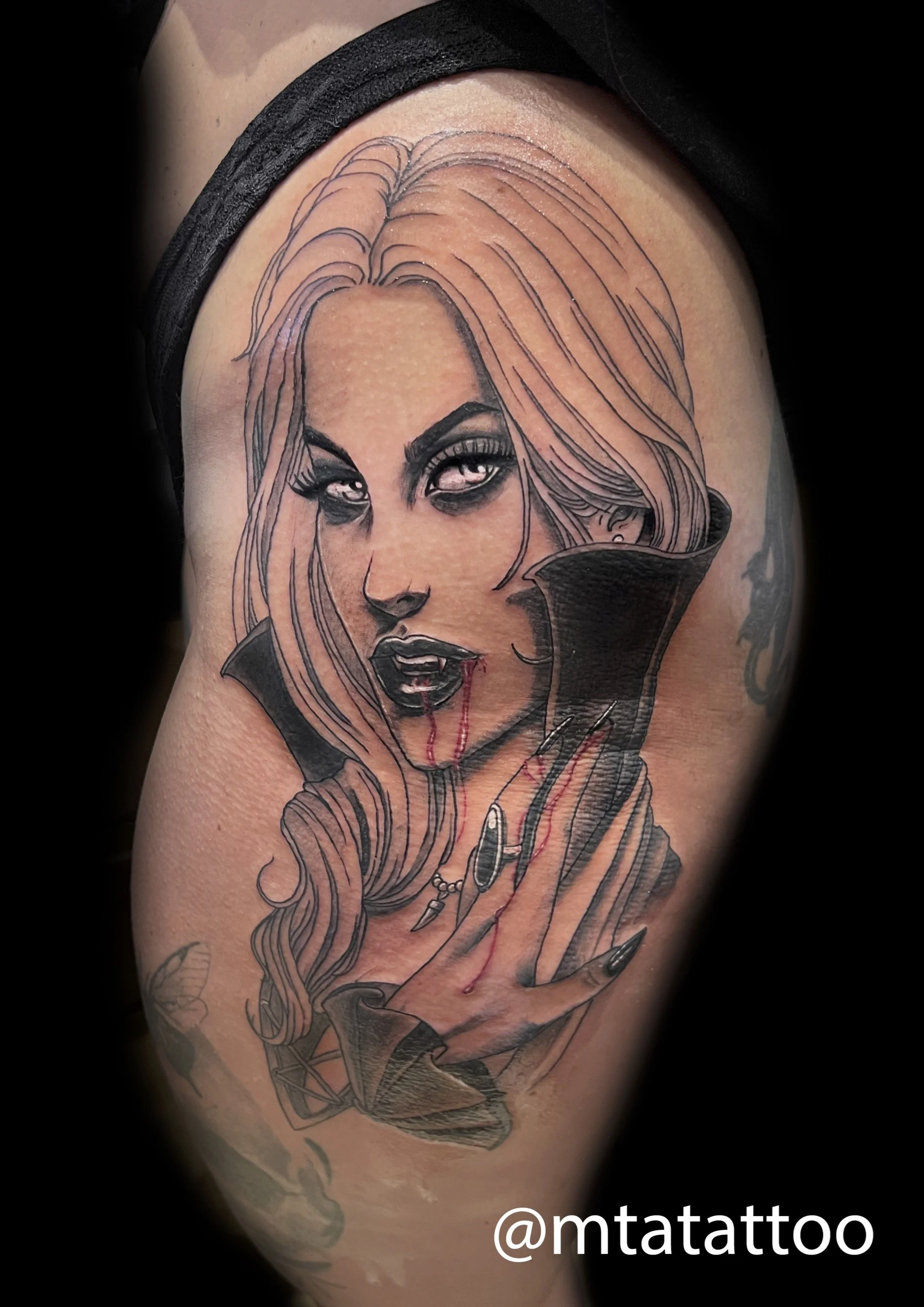 Tattoo di una donna con capelli lunghi, occhi intensi, labbra nere, con unghie nere, e una collana con pendenti, in stile dark.