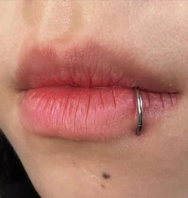 Labbra di una persona con un piercing alla bocca