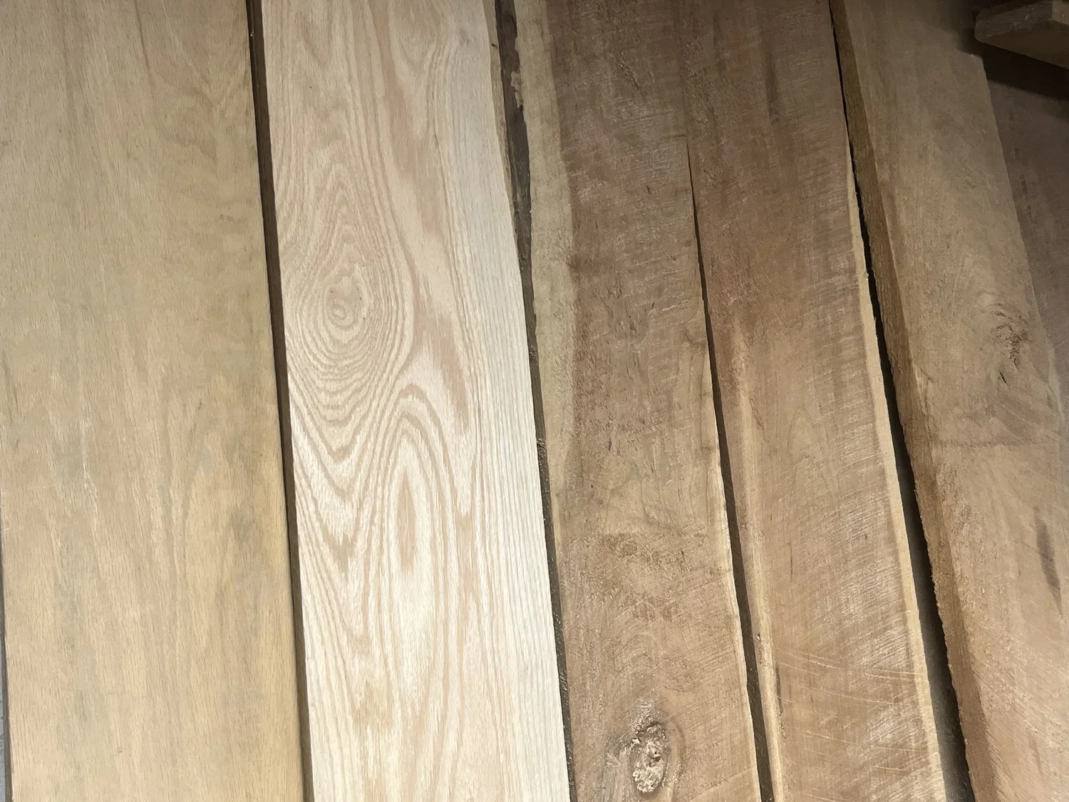Close-up of wooden planks, showing various shades of light and dark wood grain, arranged horizontally.