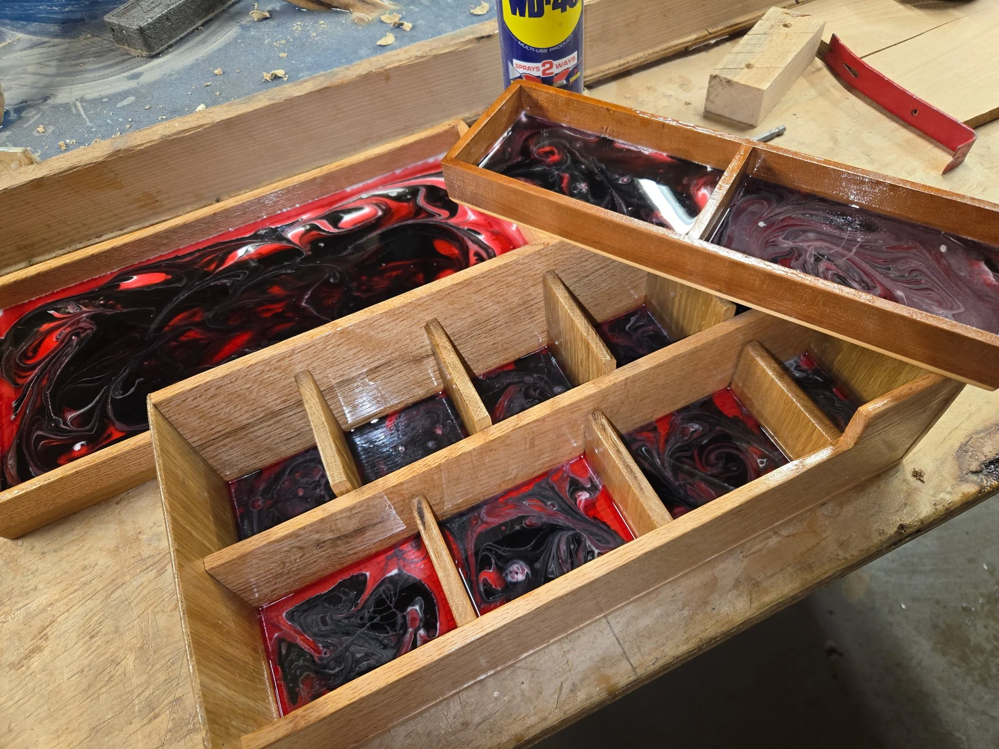Wooden soap mold filled with swirling black, red, and white soap.