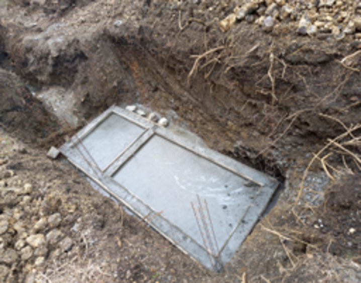 Una puerta metálica en una excavación en el suelo.