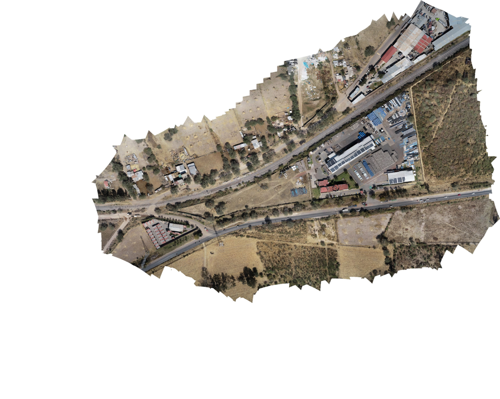 Vista aérea de un área urbana con calles, edificios y áreas verdes.