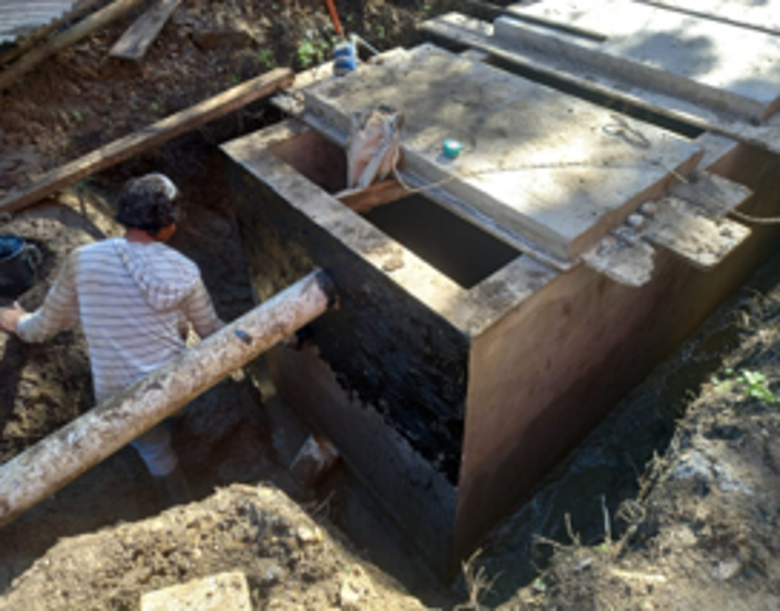 Persona trabajando en una estructura de concreto en construcción.
