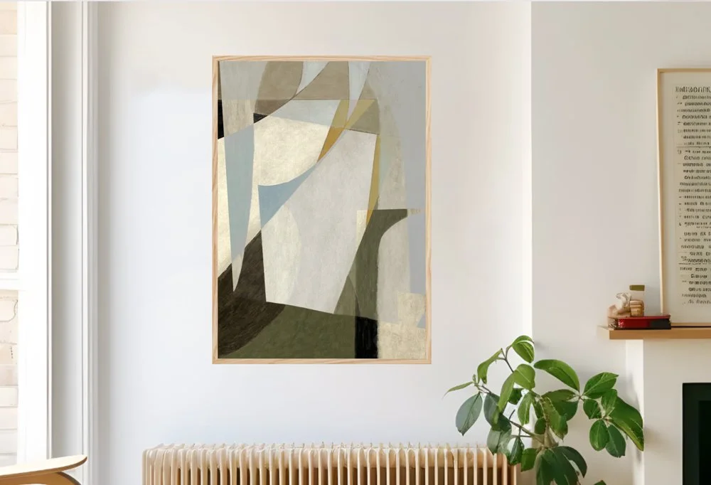 Abstract artwork with geometric shapes in neutral tones hanging on a white wall inside a modern living room with a potted plant and a radiator.