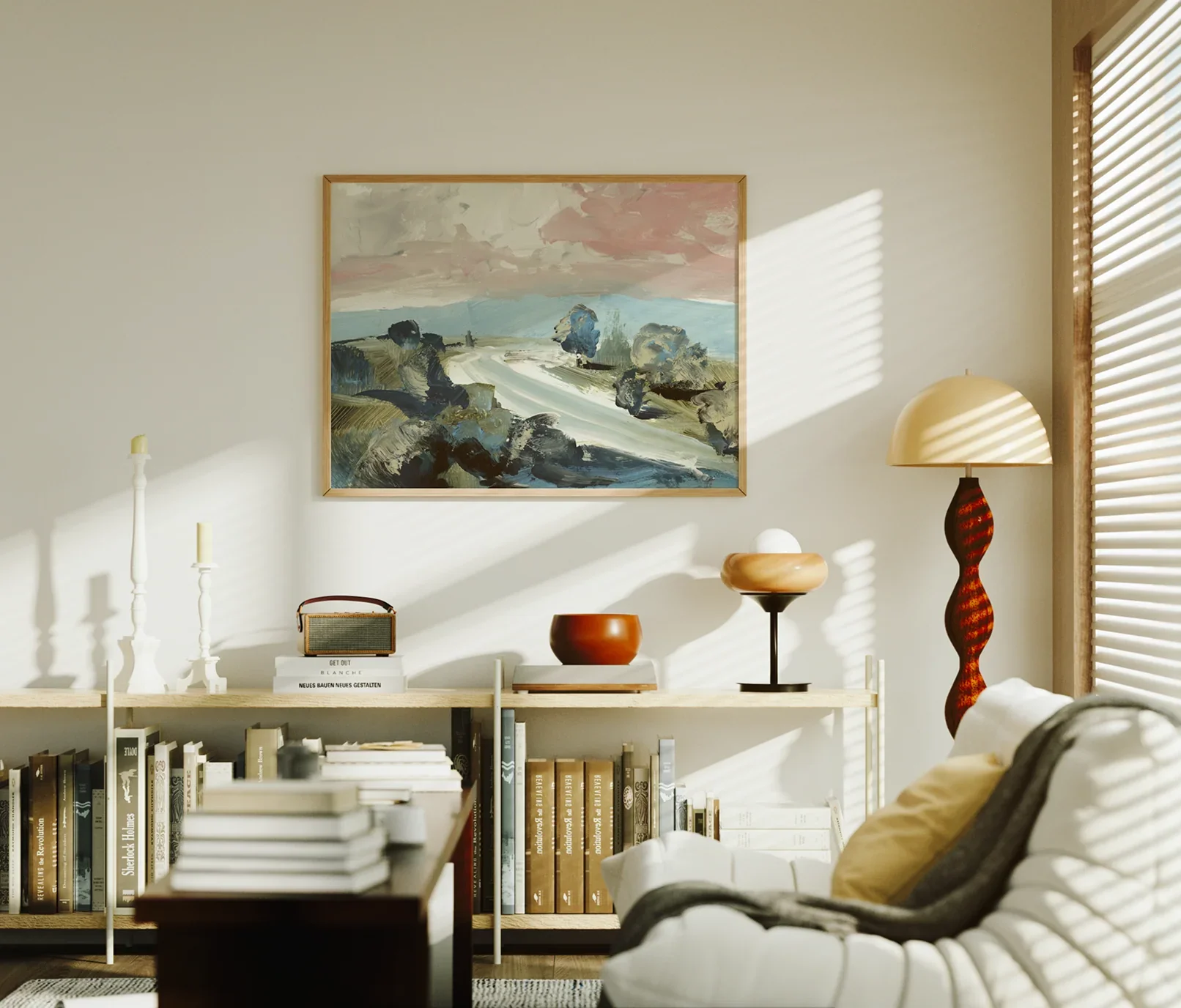 A cozy living room with a beige wall, a large abstract landscape painting, and a tall floor lamp with a wavy red base. A white bookshelf filled with books and decorative items is under the painting, with sunlight casting shadows through window blinds.
