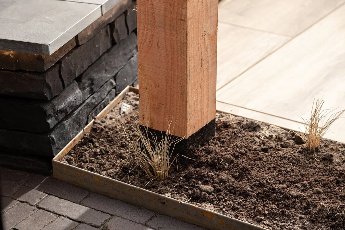 plantenbak plaatsen met tuinverlichting en siergras met stalen rand in ommen