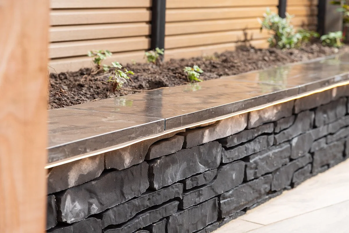 gemetselde plantenbak laten plaatsen met mooie beplanting in heeten