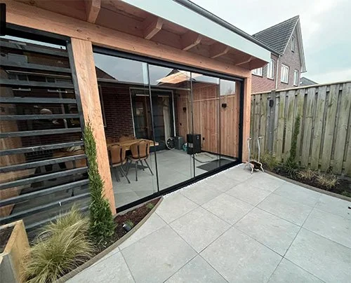 tuin aanpakken met nieuwe bestrating en mooie planten, overkaping laten plaatsen met sfeervolle tuinverlichting aan de schutting in hengelo en deventer