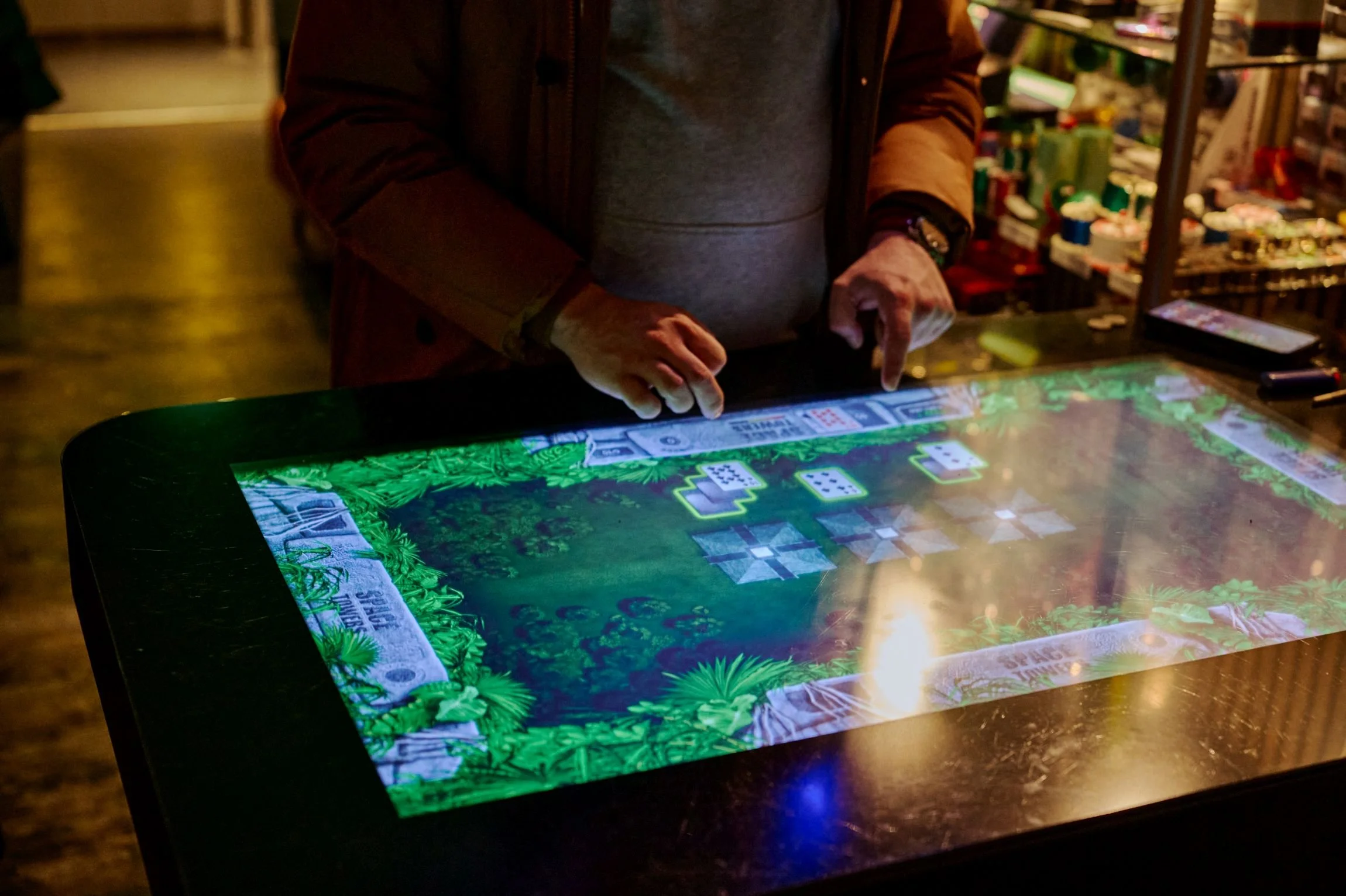 Persoon speelt een digitaal casinospel op een interactieve tafel in een casino of gokhal.