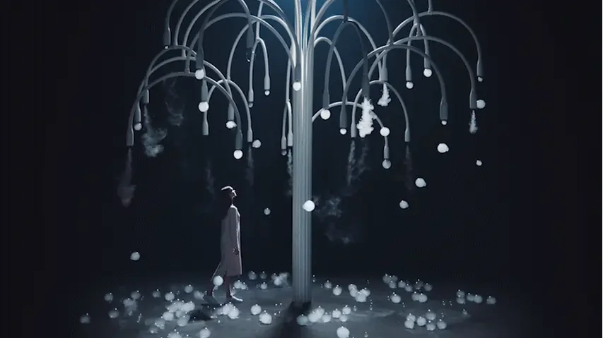 Person standing under an abstract illuminated tree with glowing white bubbles hanging from the branches in a dark setting.