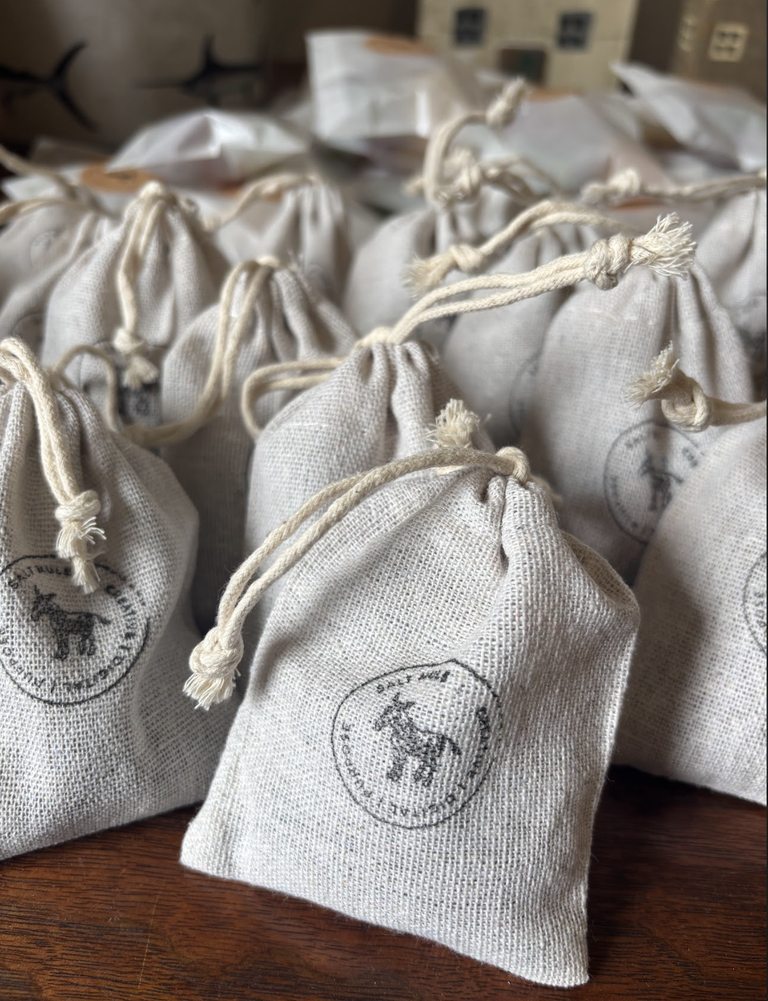Multiple beige cloth bags tied with strings, stamped with a logo featuring a buffalo and the words 'Olde Wild Buffalo'.