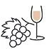 A bunch of grapes next to a glass of wine.