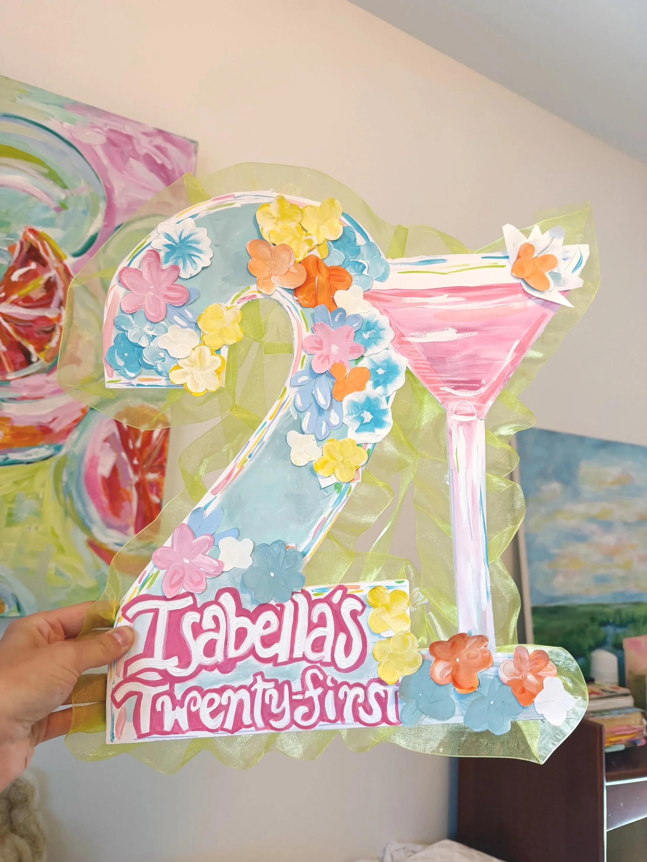 Decorative gift bag with colorful paper flowers and hand-painted design featuring a letter 'T' and a story about fairy-entropy.