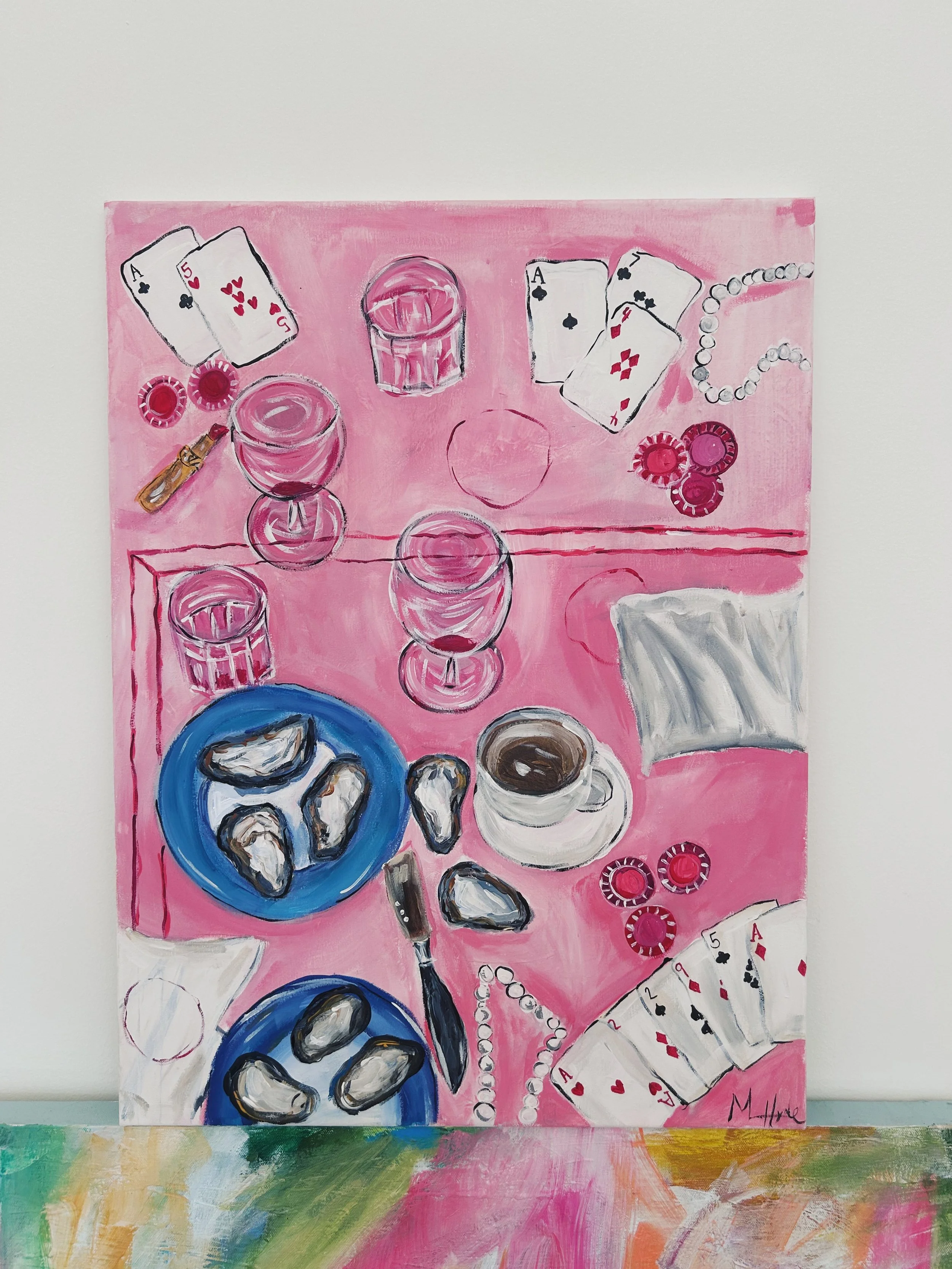Painting of a pink table setting with playing cards, oysters on blue plates, a cup of coffee, poker chips, a knife, glasses, and pearl necklaces.