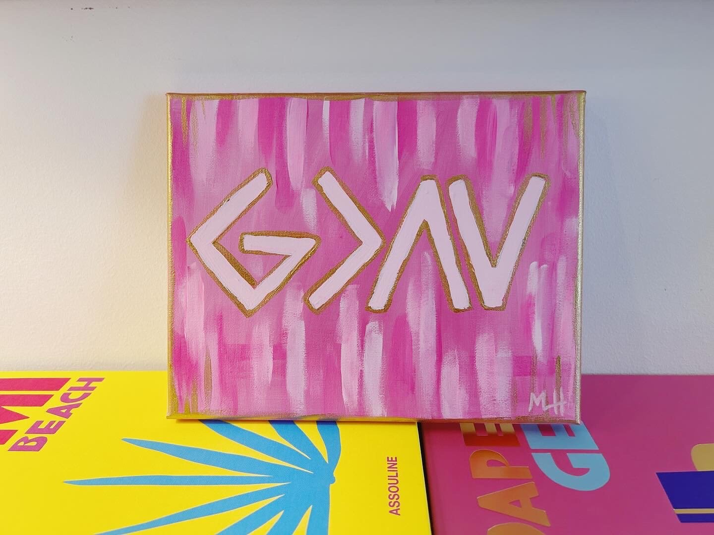 Pink canvas with abstract white and gold geometric shapes and lines, signed 'MH' in the bottom right corner, against a background of pink vertical streaks.