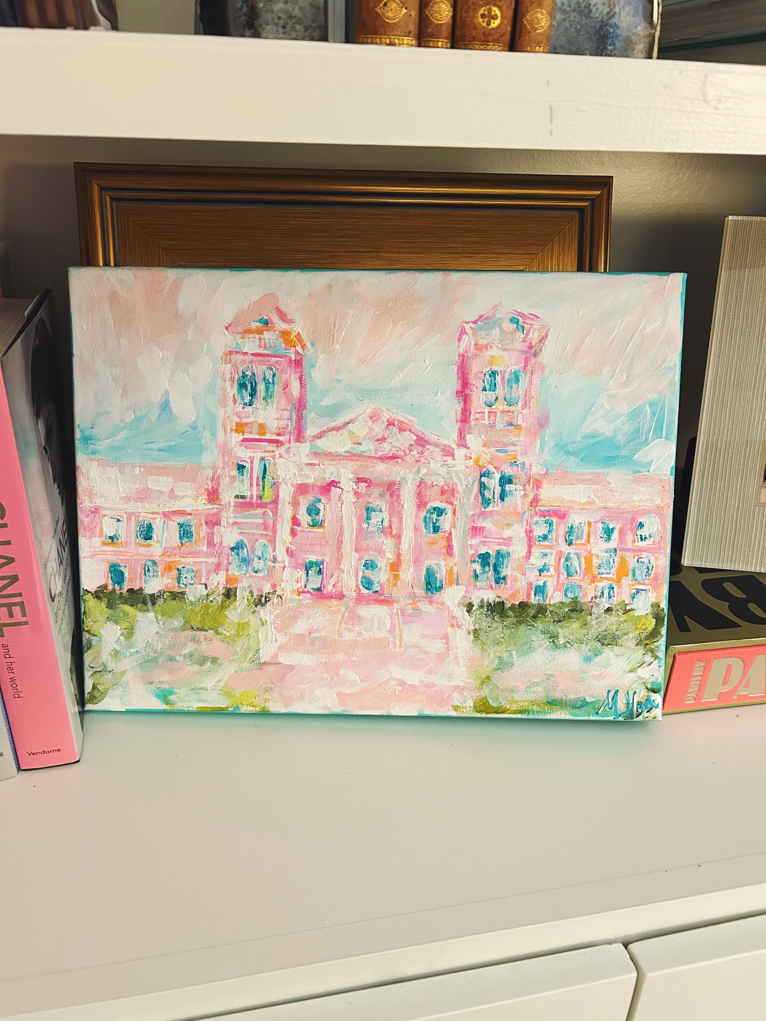 A pastel-colored painting of a large, symmetrical building with twin towers, set against a sky with light blue and pink hues, with green bushes in the foreground.