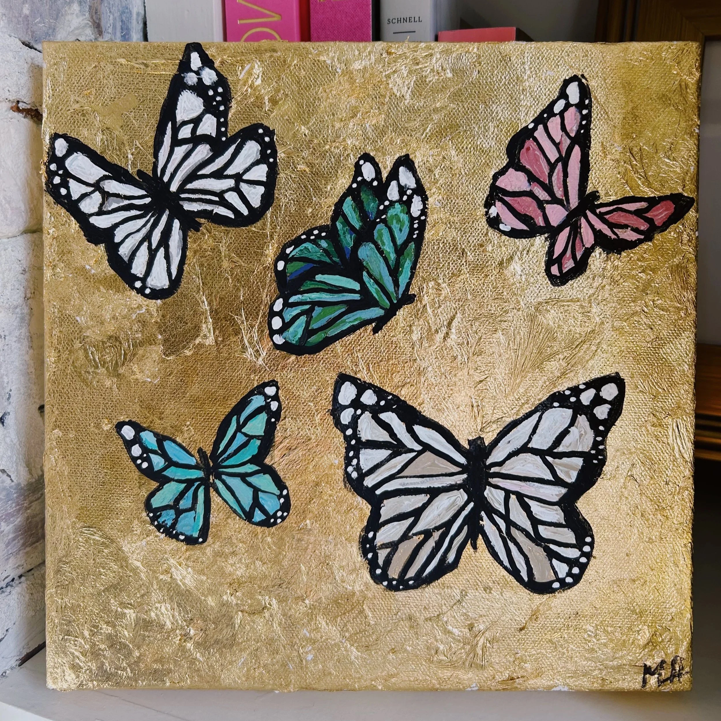 Painting of six colorful butterflies with black outlines on a gold background.