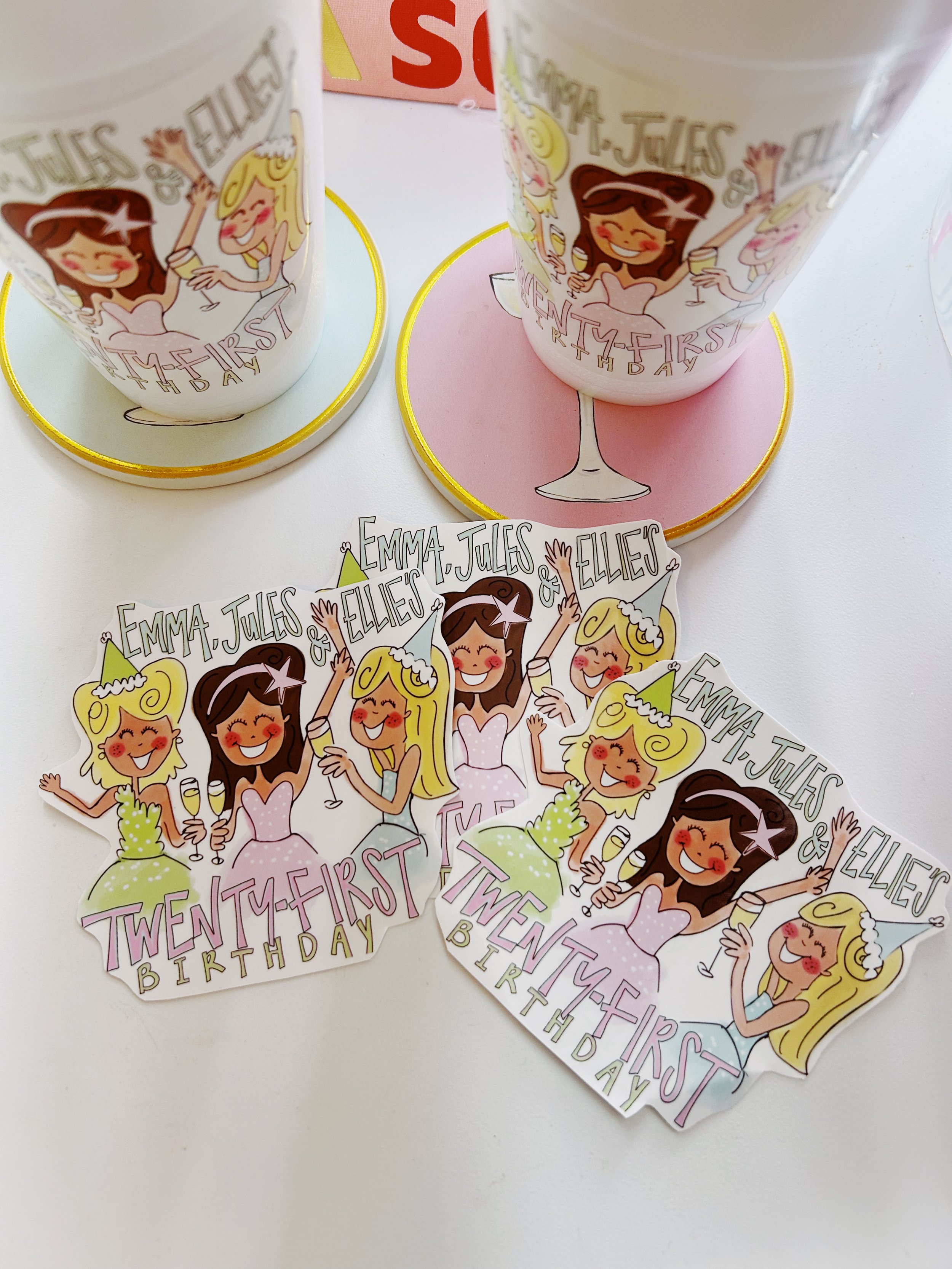 Invitation cards and party cups with cartoon illustrations of girls celebrating a twenty-first birthday, decorated with champagne glasses and birthday hats, for Emma, Jules, and Ellie.