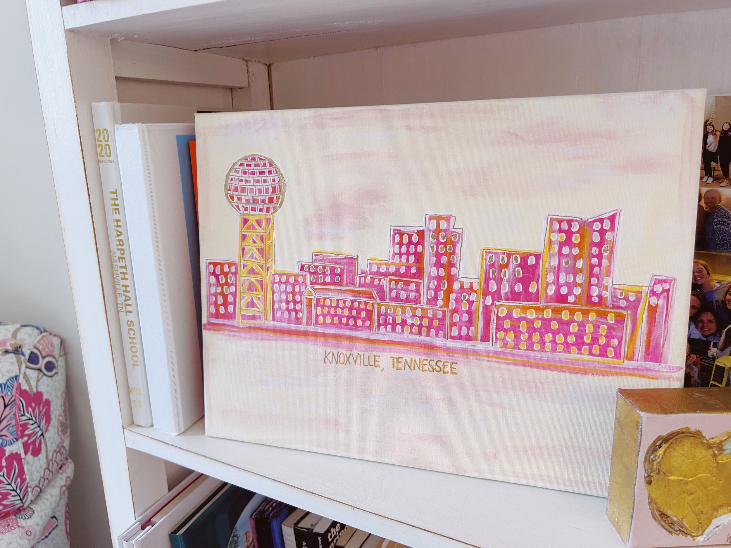 A painting of the Knoxville, Tennessee skyline with pink and yellow colors, featuring the famous Sunsphere.