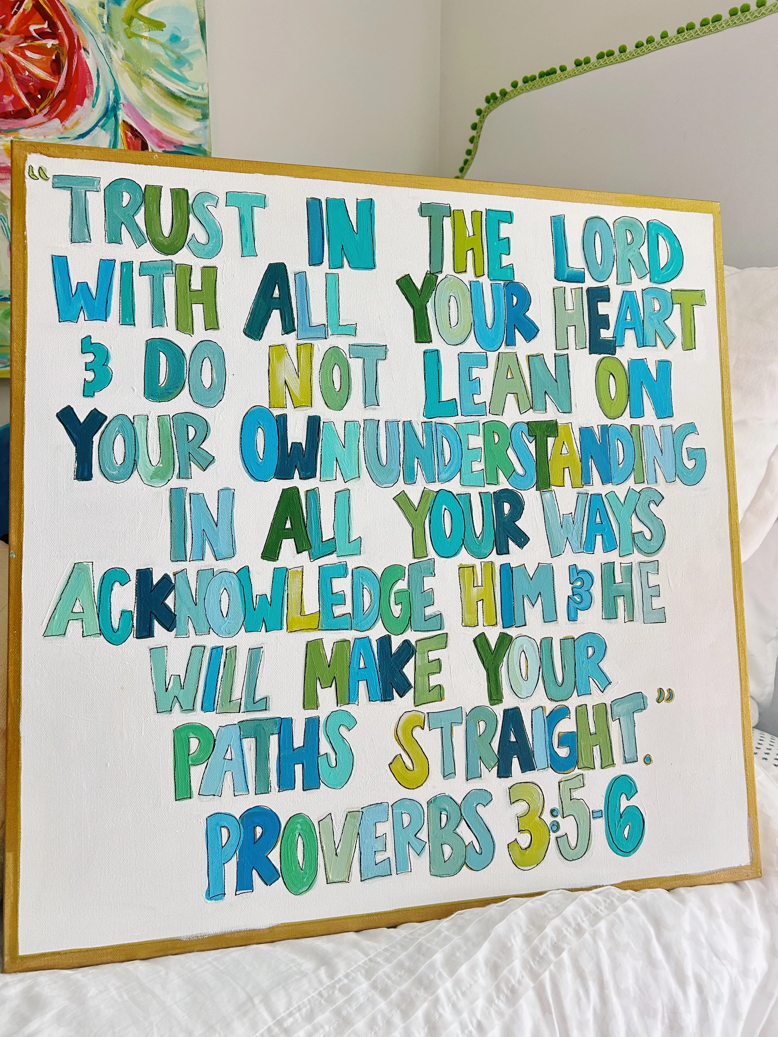 Colorful hand-painted wooden sign with a biblical quote from Proverbs 3:5-6, featuring multicolored letters in shades of blue, green, and yellow.