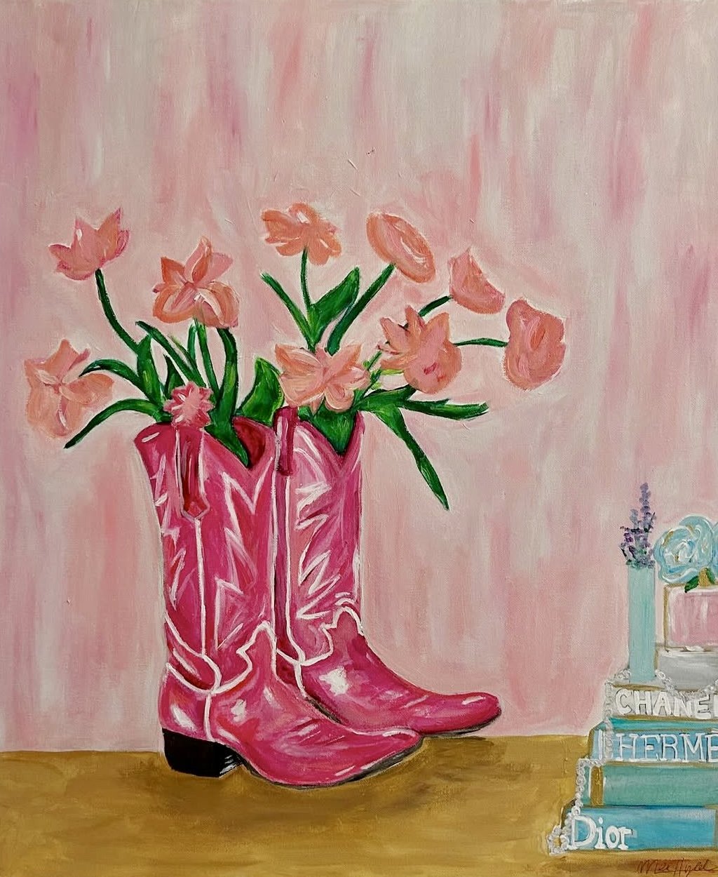 A painting of pink cowboy boots repurposed as a vase, filled with pink flowers, against a pink background. To the right, there is a stack of high-end fashion books topped with a small bouquet of flowers.