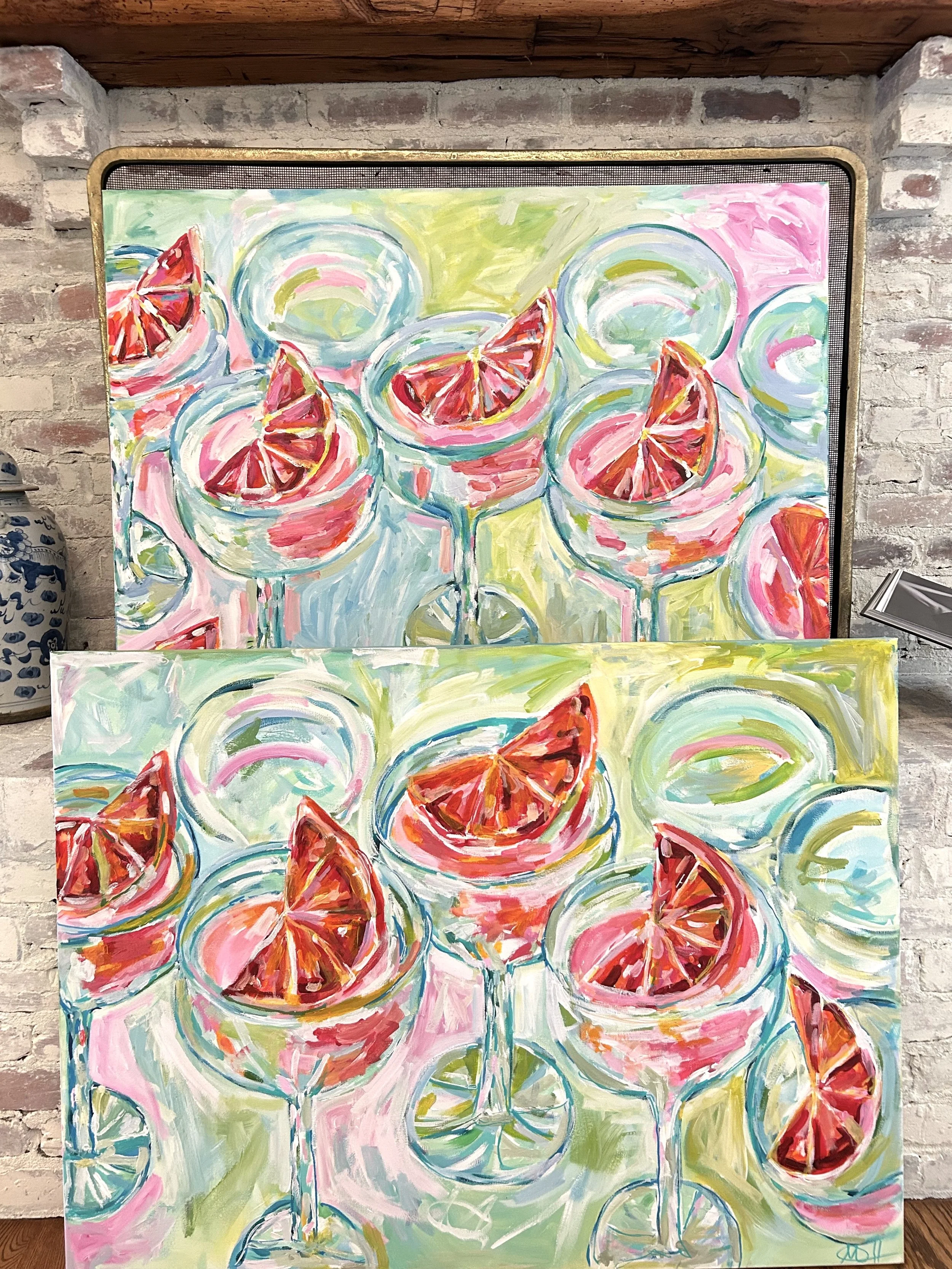 Two colorful paintings of margarita glasses filled with drinks and garnished with lime wedges and fruit slices, set against abstract backgrounds.