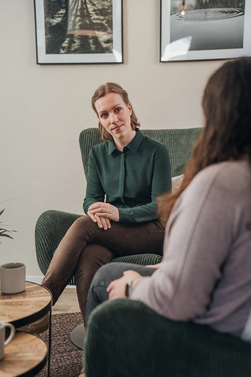 Zwei Frauen führen ein Gespräch in einem gemütlichen Raum.