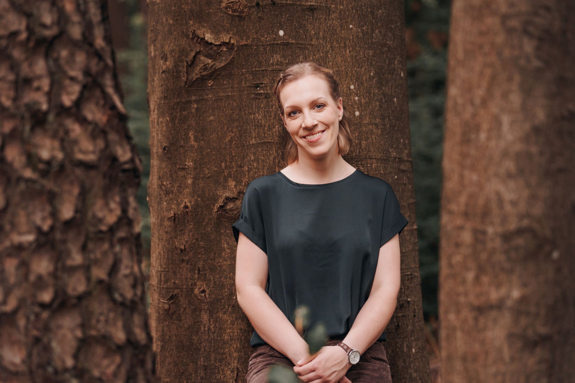 Patrizia Lehmann steht vor einem Baum und lächelt in die Kamera.