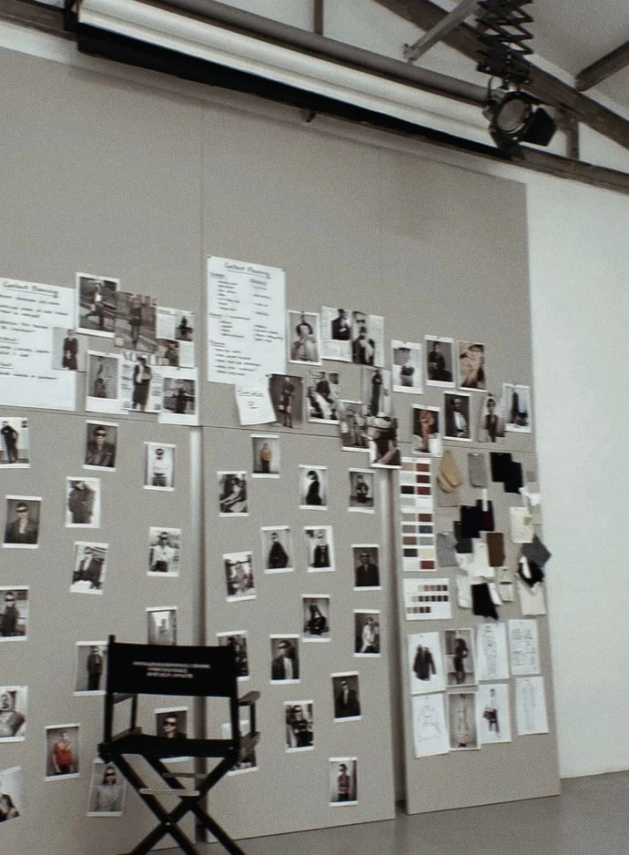 Display wall with multiple photographs, mood boards, color swatches, and design sketches, likely for a fashion or photography project.