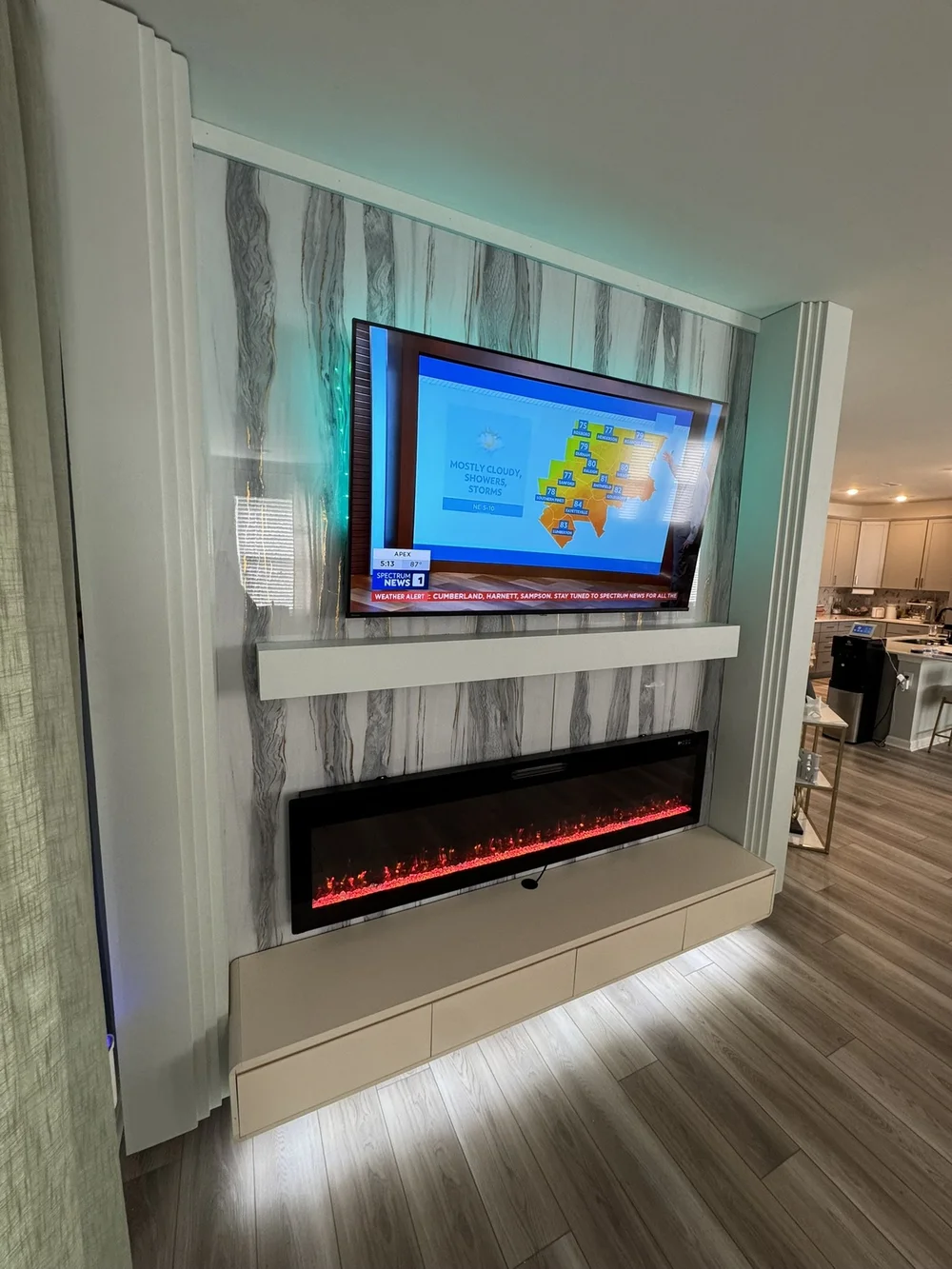 Marble-look TV wall with a linear fireplace and fluted side panels
