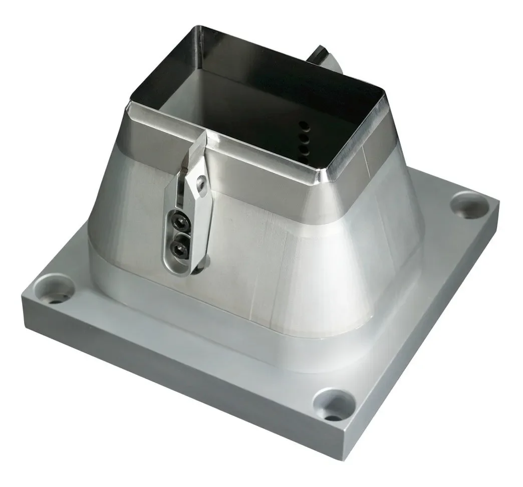 Metallic industrial component or mold with a square top and four mounting holes on a flat base.