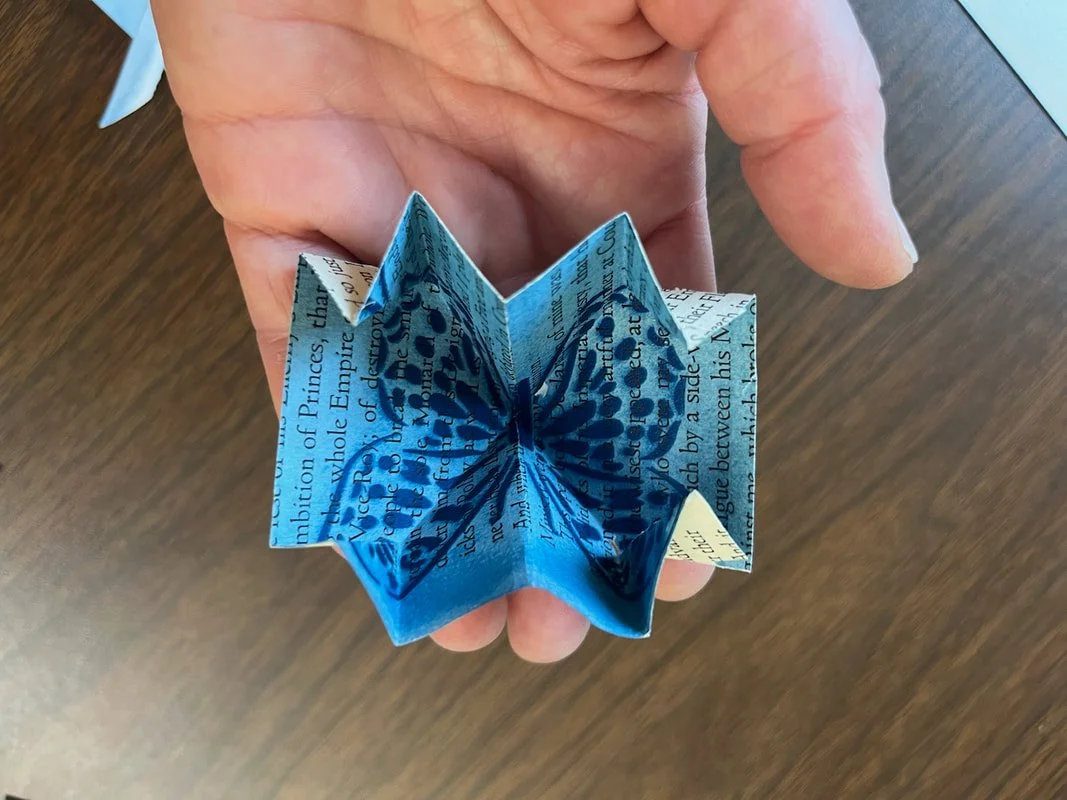 Paper art of a butterfly held in a person's hand