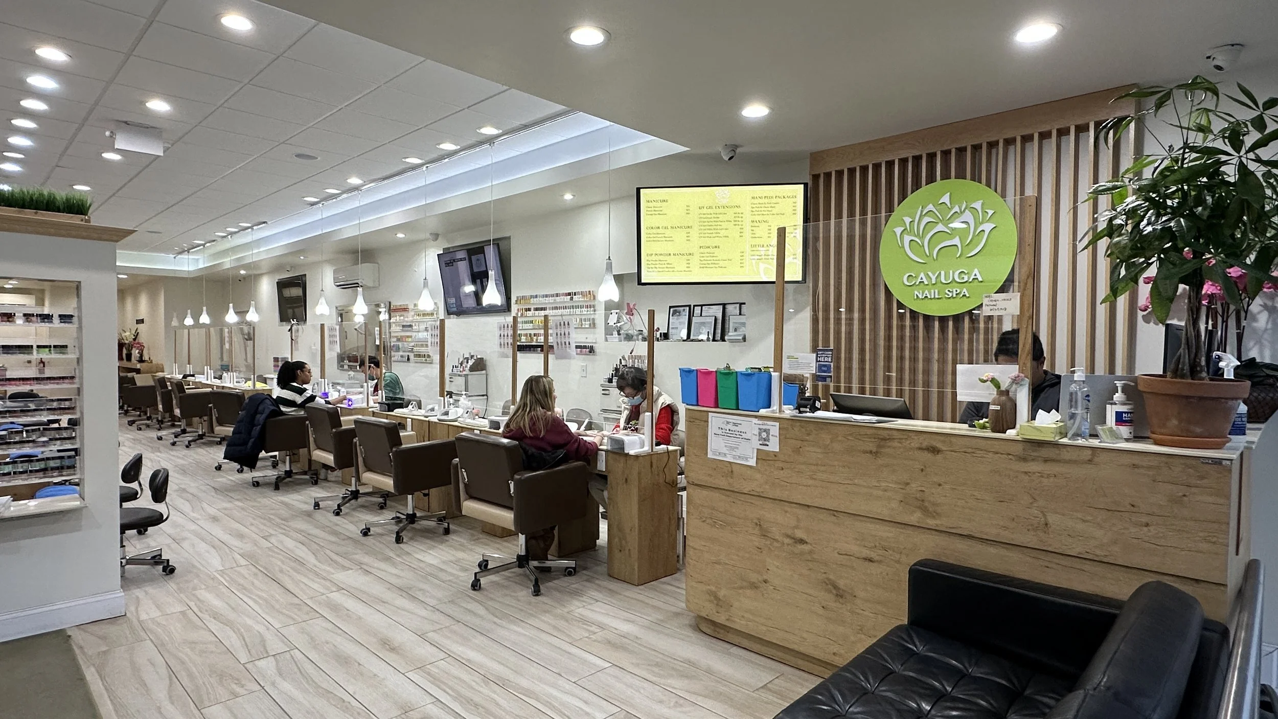 Photo of the interior of Cayuga Nail Spa in Downtown Ithaca with two women getting their nails done at the nail bar.