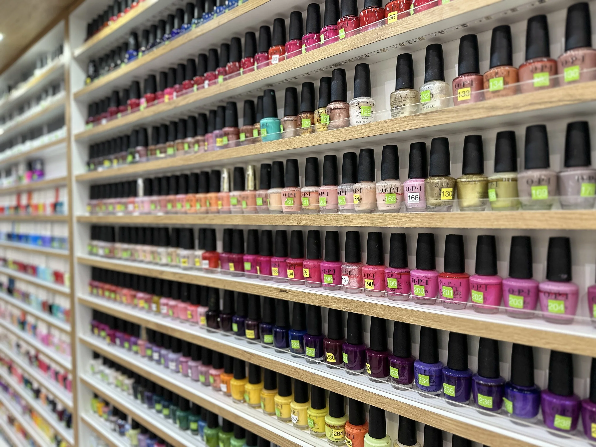 Wall of OPI brand nail polish color options at Cayuga Nail Spa