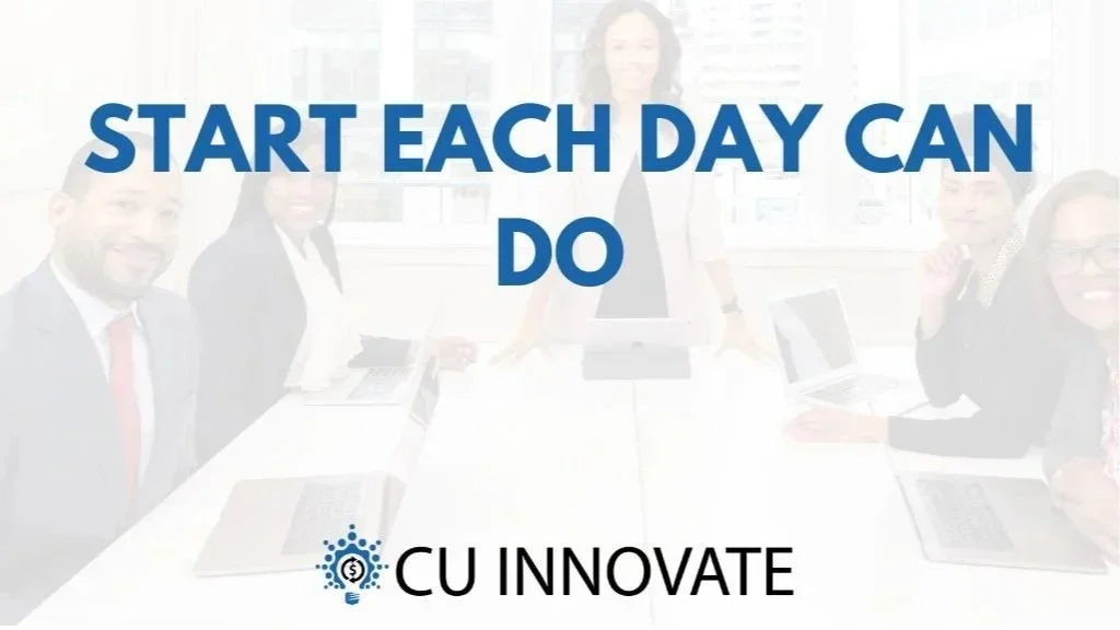 A diverse group of six business people sitting around a conference table with laptops, smiling at the camera during a meeting.