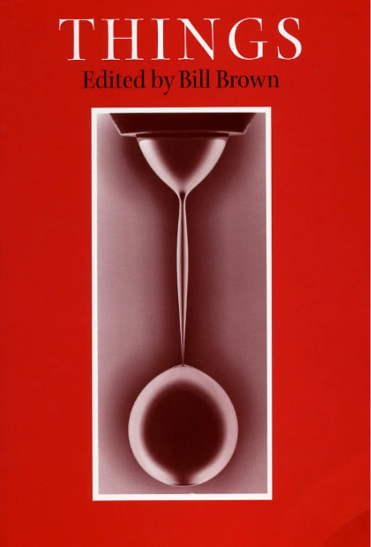 The cover for Things edited by Bill Brown. The red cover has a central image framed in white of a greyscale hourglass-like shape. The top of the hourglass is normal with the midsection stretched out to an almost perfectly circular orb in the bottom
