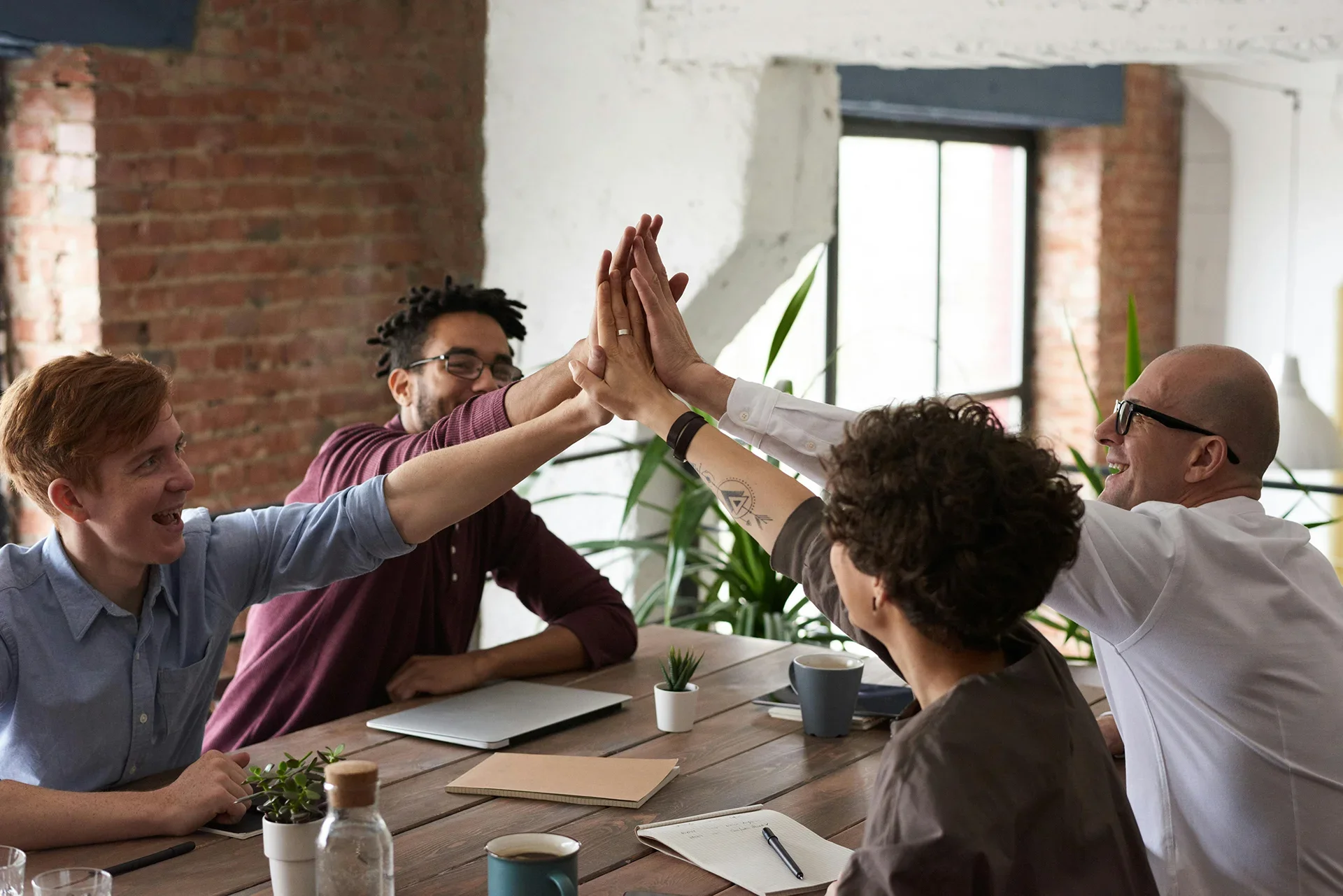 Team of colleagues high-fiving one another.