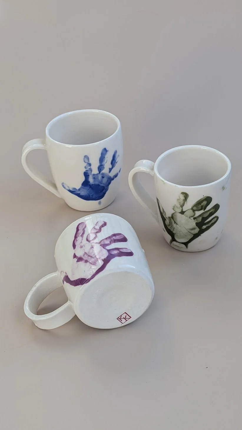 Baby handprints on porcelain mugs. 2025.