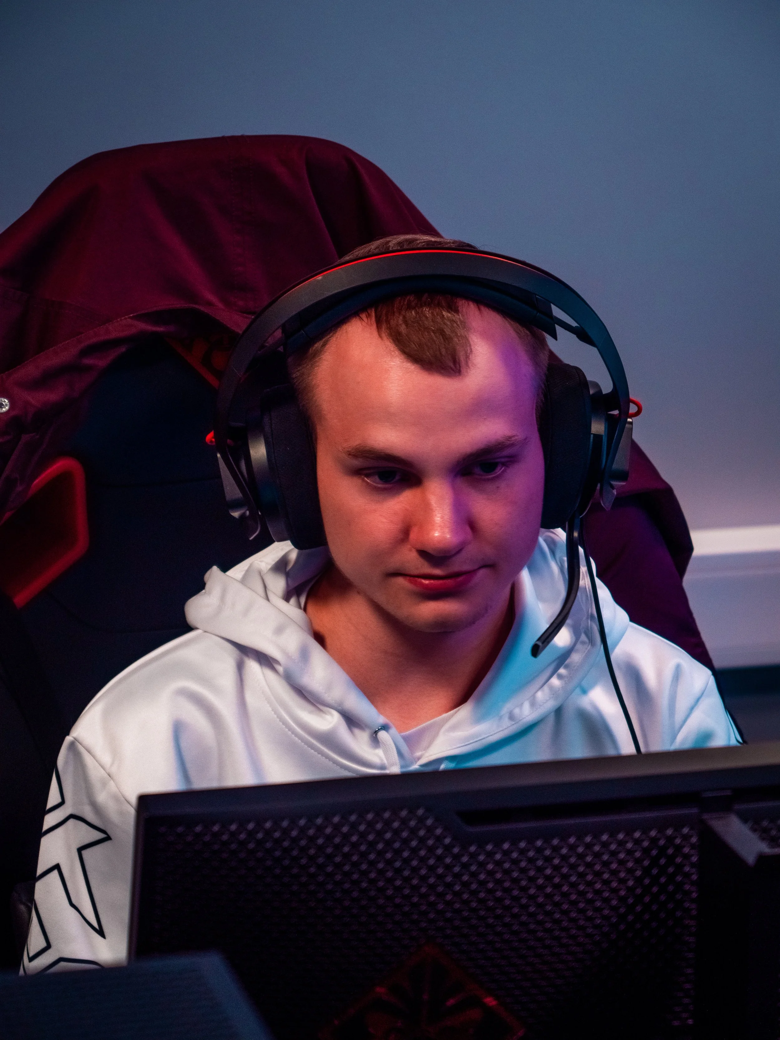 En ung mann med hodesett som ser på en dataskjerm.