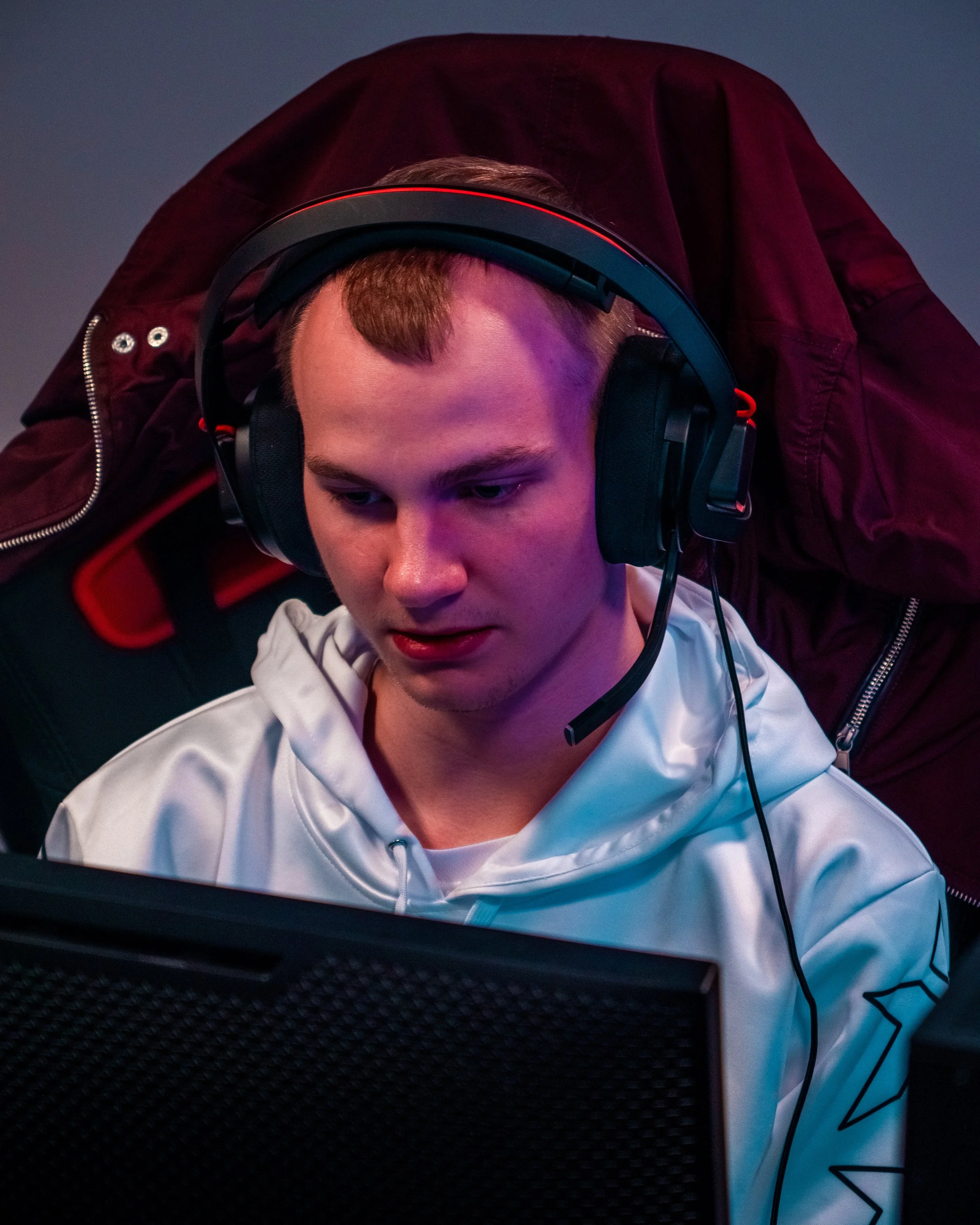 En ung mann bruker hodetelefoner og ser konsentrert på en skjerm.