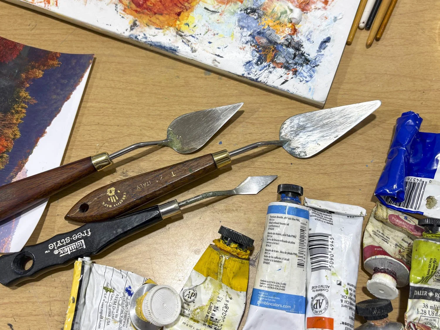 Ray Byram, fine art landscape painter, in his studio with his paints and palette knives.