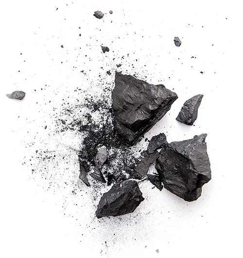 Pile of smashed black, charcoal-type rocks, on a white background.