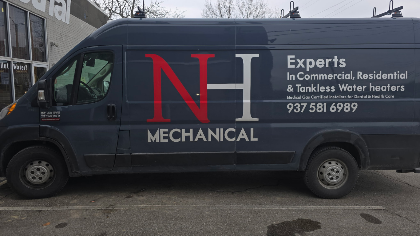 A black service van with company branding and contact information for N H Mechanical, specializing in commercial, residential, and tankless water heaters.