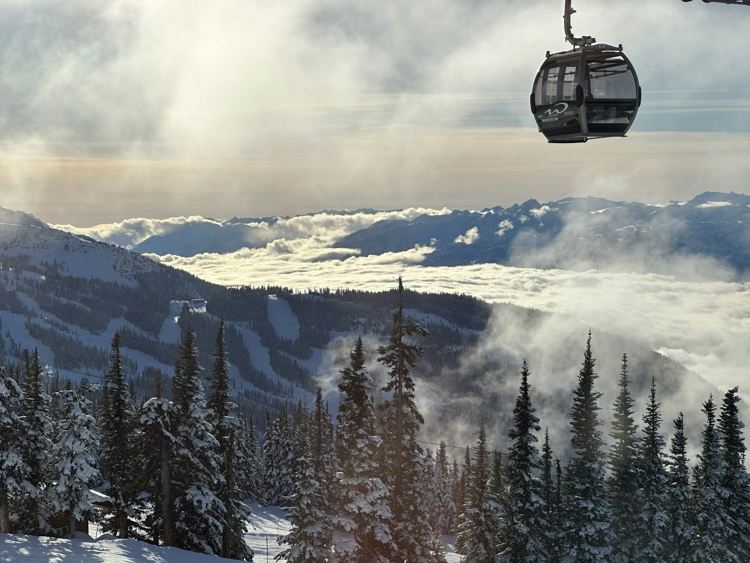 Ski lift at Whistler Blackcomb ski resort overlooking snowy alpine terrain, showcasing premier winter mountain travel in British Columbia